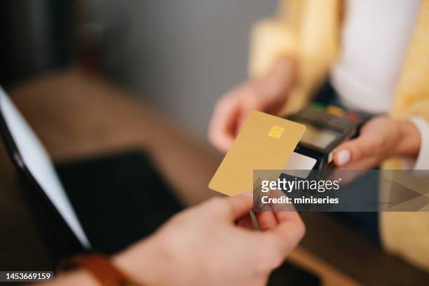 close up photo of woman hands paying with credit card in a home decor store - debit card stock pictures, royalty-free photos & images