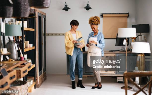 two smiling colleagues working together in a home decor store - sales assistant furniture stock pictures, royalty-free photos & images