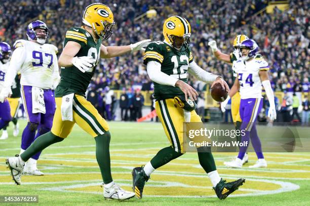 Aaron Rodgers of the Green Bay Packers celebrates with Tyler Davis of the Green Bay Packers after running for a two yard touchdown during the fourth...