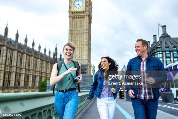 glückliche kaukasische freunde, die london besuchen und die wahrzeichen der stadt erkunden - british culture walking stock-fotos und bilder