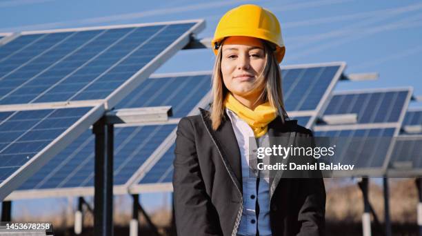 porträt einer ingenieurin in einem solarkraftwerk. solarstadt. - handwerker weißer helm stock-fotos und bilder