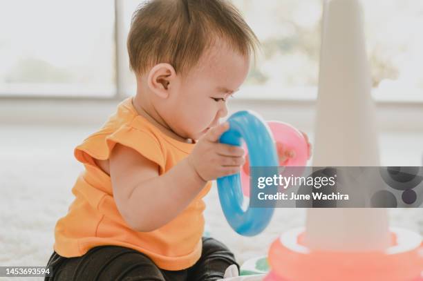 child little baby playing toys colorful plastic blocks at home. - baby creativity ideas stock-fotos und bilder