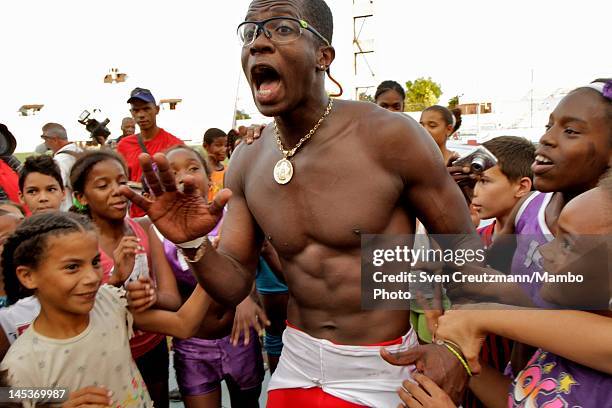 Dayron Robles of Cuba cries out as he makes his way through dozens of children after finishing a 110 meter hurdles race in the Pan-American stadium...