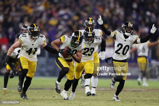 Minkah Fitzpatrick of the Pittsburgh Steelers celebrates with teammates after intercepting a pass from Tyler Huntley of the Baltimore Ravens during...