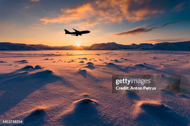 airplane in the sunset sky under a winter landscape - clouds from aircraft point of view stock pictures, royalty-free photos & images