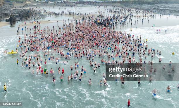 An aerial view of swimmers wading into the sea at Crooklets Beach for the annual Christmas Day Swim on December 25, 2022 in Bude, England.