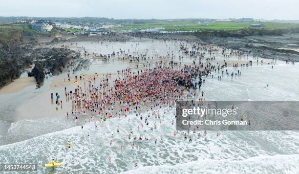 An aerial view of swimmers wading into the sea at Crooklets Beach for the annual Christmas Day Swim on December 25, 2022 in Bude, England.