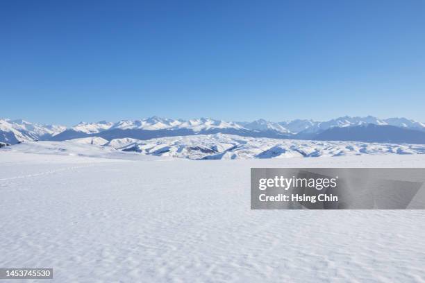 snow mountain and grassland in winter - nieve profunda fotografías e imágenes de stock
