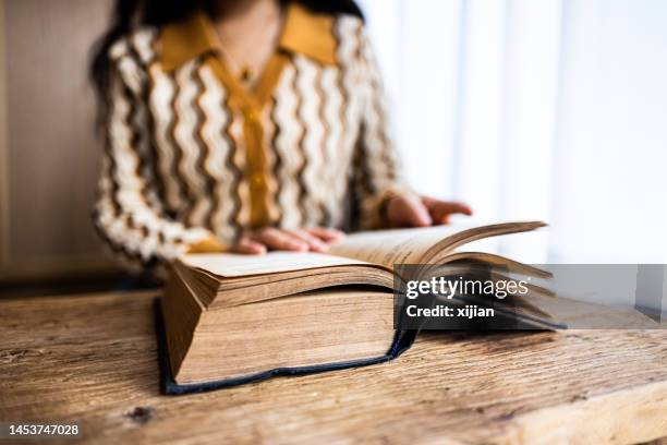 mujeres asiáticas leyendo un libro en casa - libro viejo fotografías e imágenes de stock