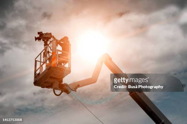 camera operator on camera crane during film set - camera operator imagens e fotografias de stock