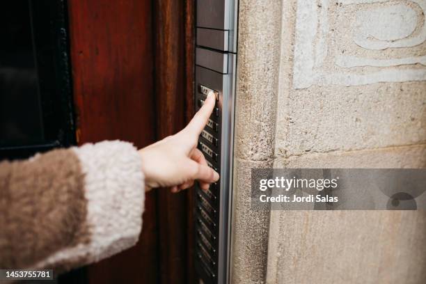 hand ringing intercom of a building - buzzer stock-fotos und bilder