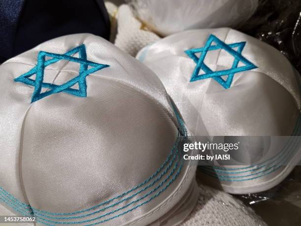 two white yarmulkes / kipa with big, blue stars of david, close-up - calotte photos et images de collection