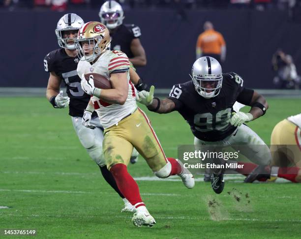 Running back Christian McCaffrey of the San Francisco 49ers carries the ball on a 38-yard run against linebacker Luke Masterson and defensive end...
