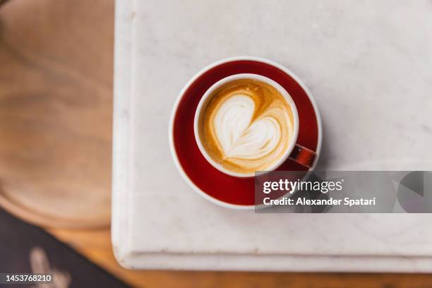 cup of cappuccino with heart shaped latte art, directly above view - latte art ストックフォトと画像