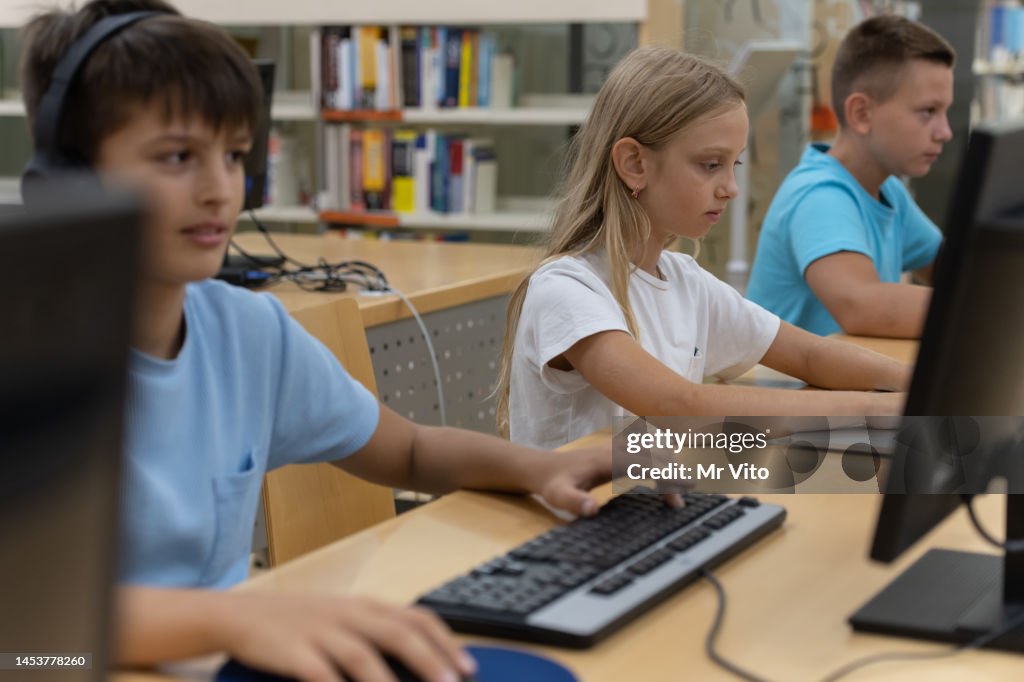 Use Computer In Library Elementary School Students On The Computers In The Library High-Res ...