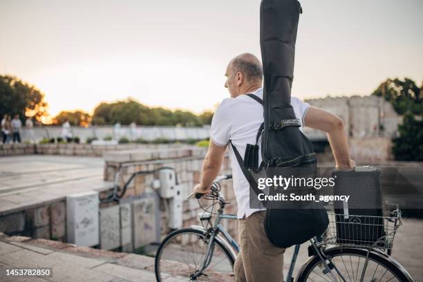 artista callejero con bicicleta - guitar case fotografías e imágenes de stock