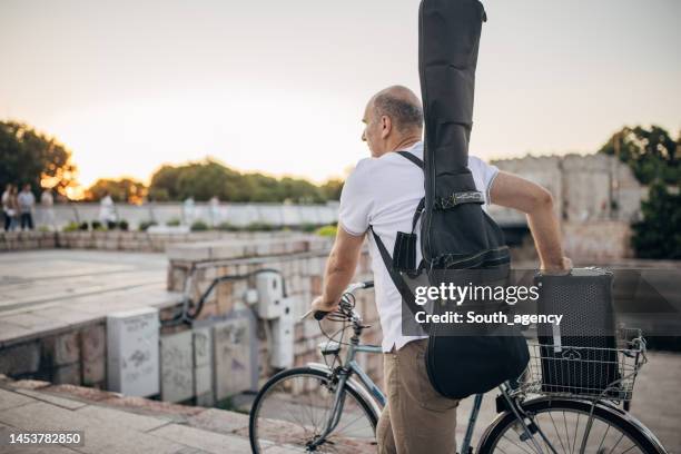 artista di strada con la bicicletta - custodia per chitarra foto e immagini stock