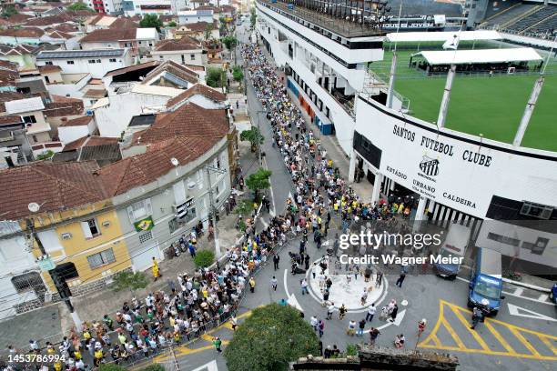 Mourners stand in line outside Vila Belmiro stadium as they wait to pay their respects to late football legend Pelé during his funeral on January 02,...