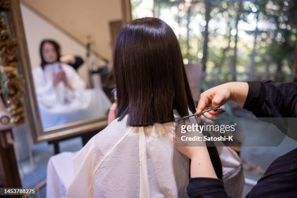mujer japonesa cortando cabello para donación de cabello - hairdresser fotografías e imágenes de stock