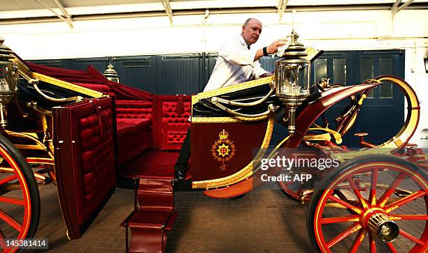 Carriage restorer David Evens cleans the 1902 State Landau coach, the coach that will carry Britain's Queen Elizabeth II during the official...
