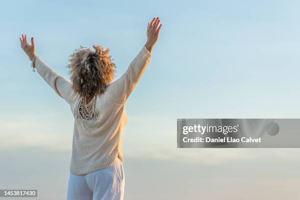 carefree black woman with raised arms - inviting gesture stockfoto's en -beelden