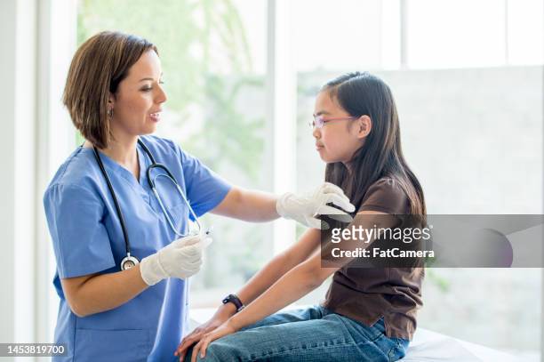 girl receiving a vaccination - s'entraîner stock pictures, royalty-free photos & images
