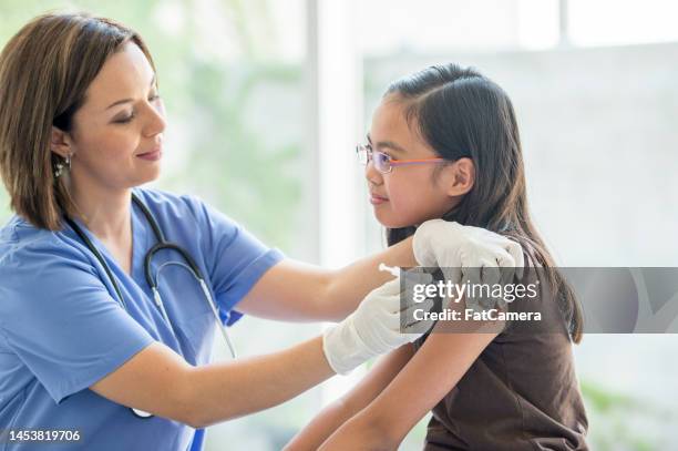 girl receiving a vaccination - cute nurses stockfoto's en -beelden