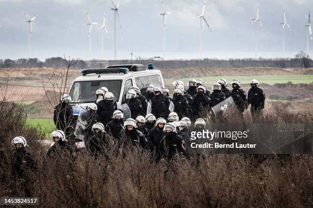 Riot police stand in front of wind turbines on January 2, 2023 in Luetzerath, Germany. The village is located on the edge of the still expanding...