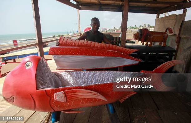 Coffin builder looks over a casket created for someone in the shape of a fish on January 27, 2010 in Accra, Ghana. The country is famed for its...