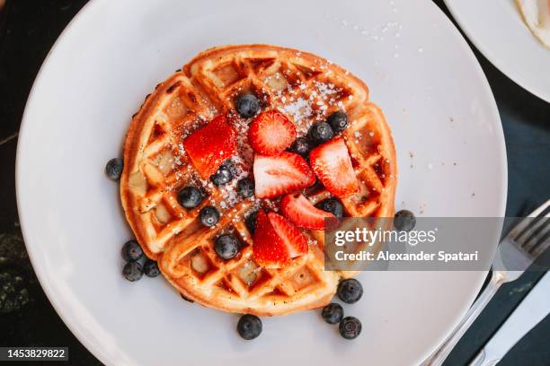 waffles with strawberries and blueberries, directly above close-up view - american breakfast stockfoto's en -beelden