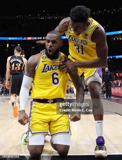 LeBron James of the Los Angeles Lakers reacts with Thomas Bryant after drawing a foul on a basket against the Atlanta Hawks during the fourth quarter...