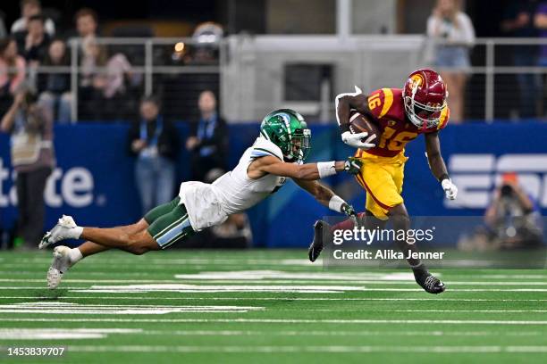 Wide receiver Tahj Washington of the USC Trojans eludes defensive back Lance Robinson of the Tulane Green Wave during the second quarter of the...