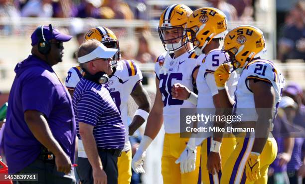 Jayden Daniels of the LSU Tigers talks with head coach Brian Kelly during the Cheez-It Citrus Bowl against the Purdue Boilermakers at Camping World...