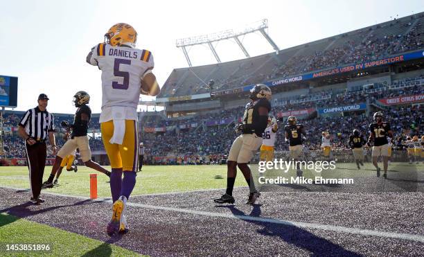 Jayden Daniels of the LSU Tigers celebrates a touchdown during the Cheez-It Citrus Bowl against the Purdue Boilermakers at Camping World Stadium on...