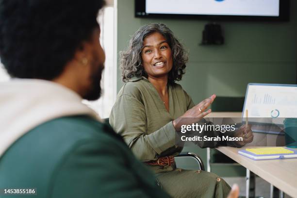 businesswoman gesturing and talking to male colleague - büro stock pictures, royalty-free photos & images