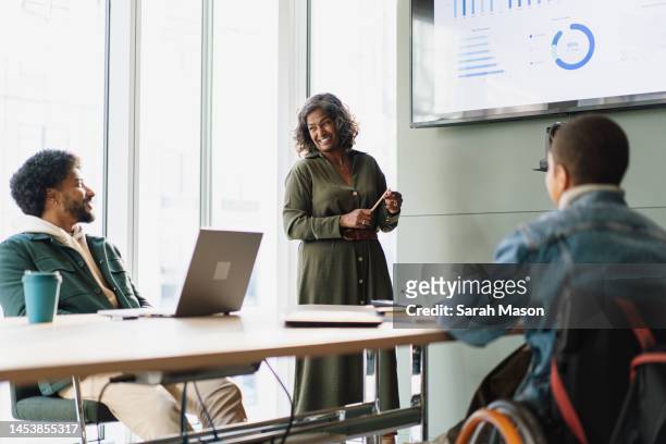 business woman doing a business presentation to colleagues - enterprise stock pictures, royalty-free photos & images