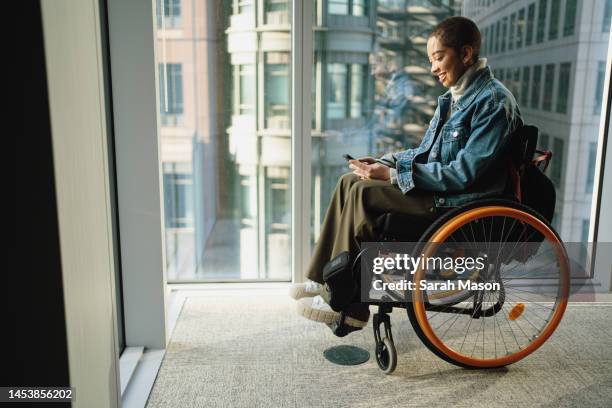 young office worker looking at phone - wheelchair fotografías e imágenes de stock