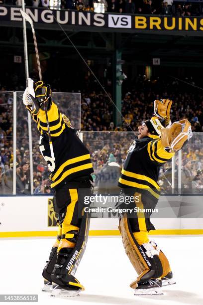 Linus Ullmark and Jeremy Swayman of the Boston Bruins celebrate after defeating the Pittsburgh Penguins in the 2023 Discover NHL Winter Classic at...