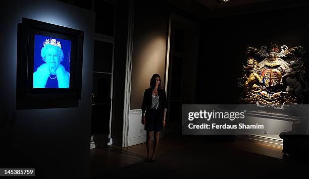 Sophie Hugh Williams poses with Chris Levine's revamped 2004 seminal 3D portrait of Her Majesty Queen Elizabeth II entitled 'Equanimity' with an...