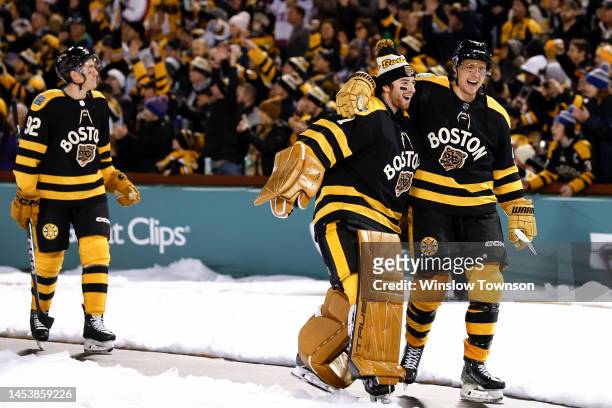 Jeremy Swayman and Hampus Lindholm of the Boston Bruins celebrate after defeating the Pittsburgh Penguins in the 2023 Discover NHL Winter Classic at...