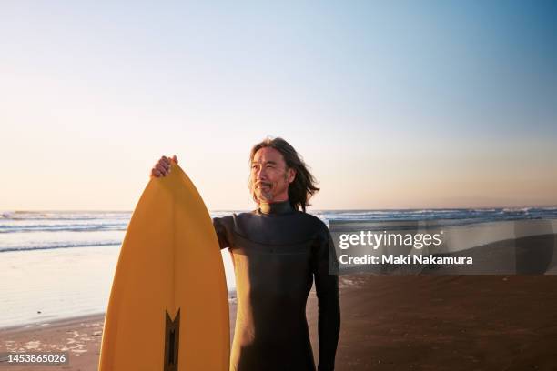 portrait of surfer man with surfboard. - asian surfer stockfoto's en -beelden