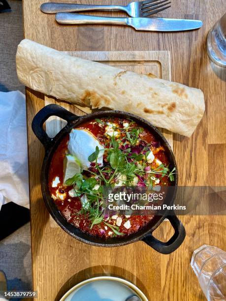 gourmet baked eggs with tomatoes, peppers, feta, sour cream and tortilla in trendy brighton restaurant; delicious vegan mexican breakfast in england in october 2020 - 20/20 stock pictures, royalty-free photos & images