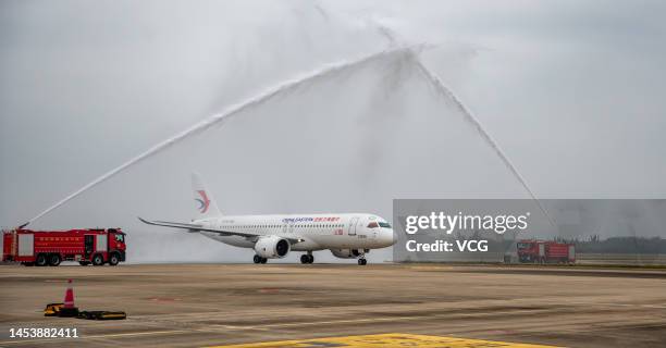 The first C919 large passenger aircraft of China Eastern Airlines passes a water gate after landing at Haikou Meilan International Airport during the...