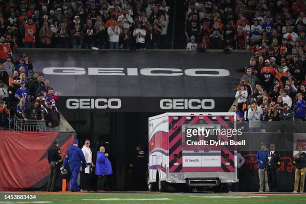 Fans look on as the ambulance leaves carrying Damar Hamlin of the Buffalo Bills after he collapsed after making a tackle against the Cincinnati...