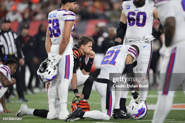 Quarterback Joe Burrow of the Cincinnati Bengals and Jordan Poyer of the Buffalo Bills take a knee after Damar Hamlin of the Bills collapsed...