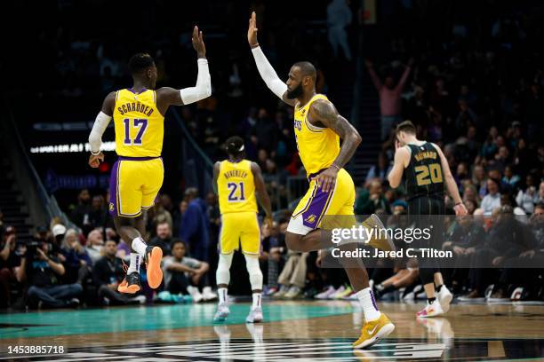 LeBron James of the Los Angeles Lakers reacts with teammate Dennis Schroder following a dunk during the second half of the game against the Charlotte...