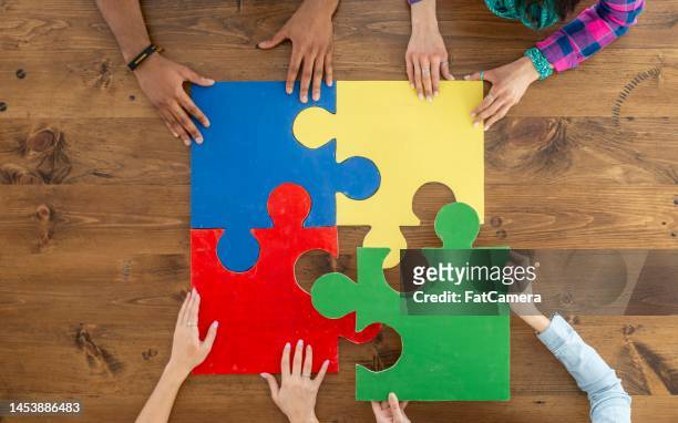 putting together a puzzle - part of team stock pictures, royalty-free photos & images