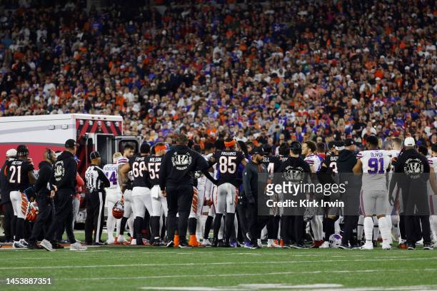 Buffalo Bills and Cincinnati Bengals players look on as Damar Hamlin of the Buffalo Bills is treated by medical personnel after being injured during...