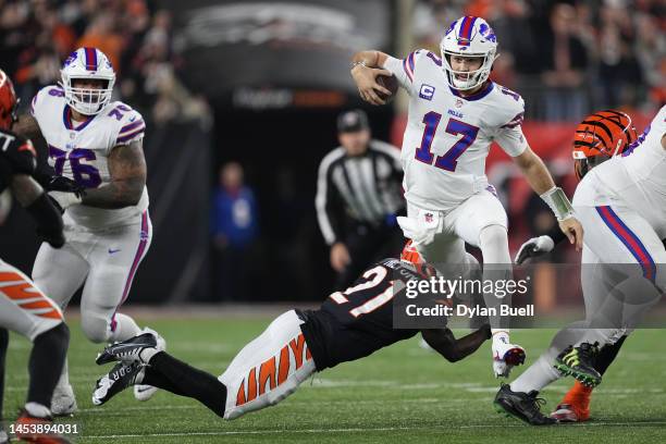 Josh Allen of the Buffalo Bills scrambles as Mike Hilton of the Cincinnati Bengals attempts a tackle during the first quarter at Paycor Stadium on...