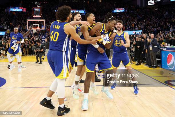 Kevon Looney of the Golden State Warriors is surrounded by teammates after he made the game-winning shot at the buzzer of double overtime to beat the...